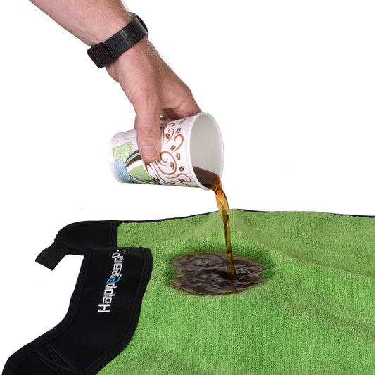 Coffee poured onto a green Happeseat waterproof car seat cover beading on the microfiber